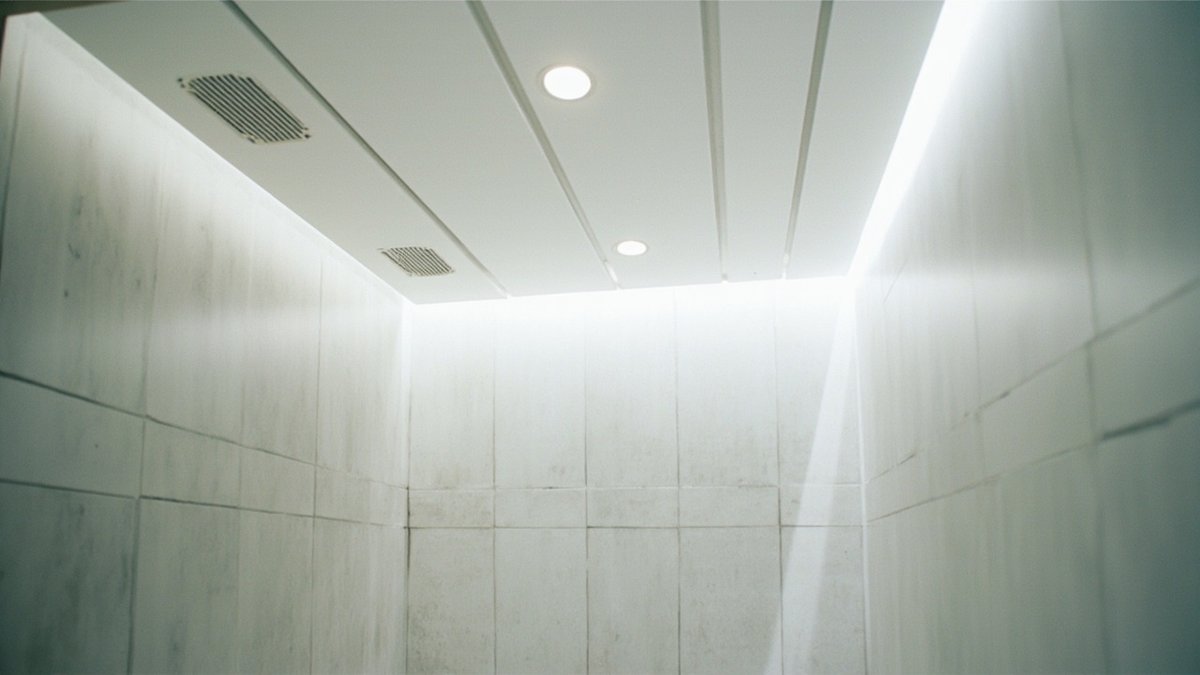 Siling jalur aluminium putih dengan downlight di bilik air berjubin kelabu