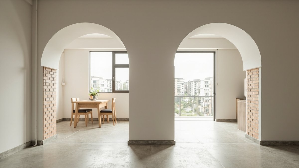 Illustrative concept design: two round-topped arched doorways with exposed brick reveals in a white wall, leading to a dining corner