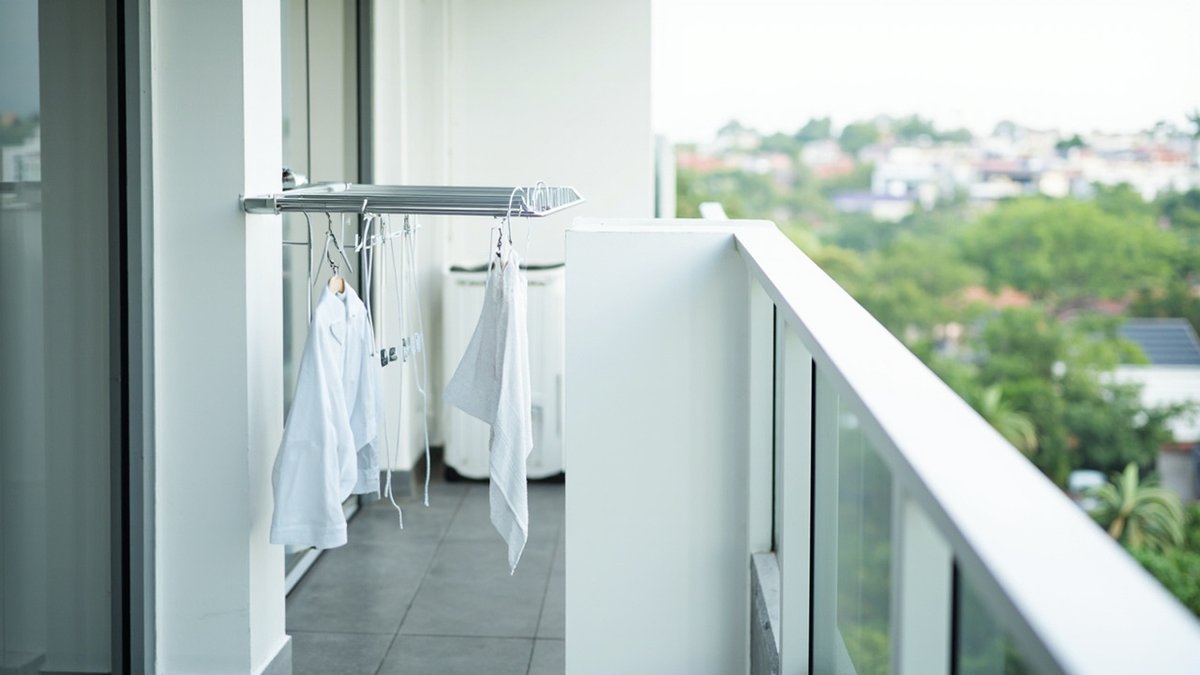 Illustrative concept design: fold-out aluminium drying rack on the balcony side wall