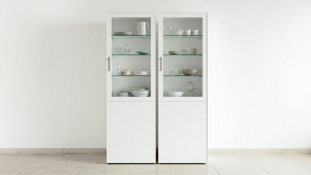 Illustrative concept design: pair of tall white cabinets with glass upper doors and shelves of white bowls, plates and glasses