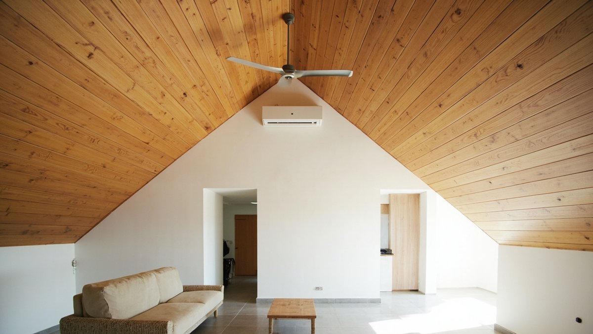 Illustrative concept design: steep pitched ceiling lined in honey timber boards with a fan hung from the ridge