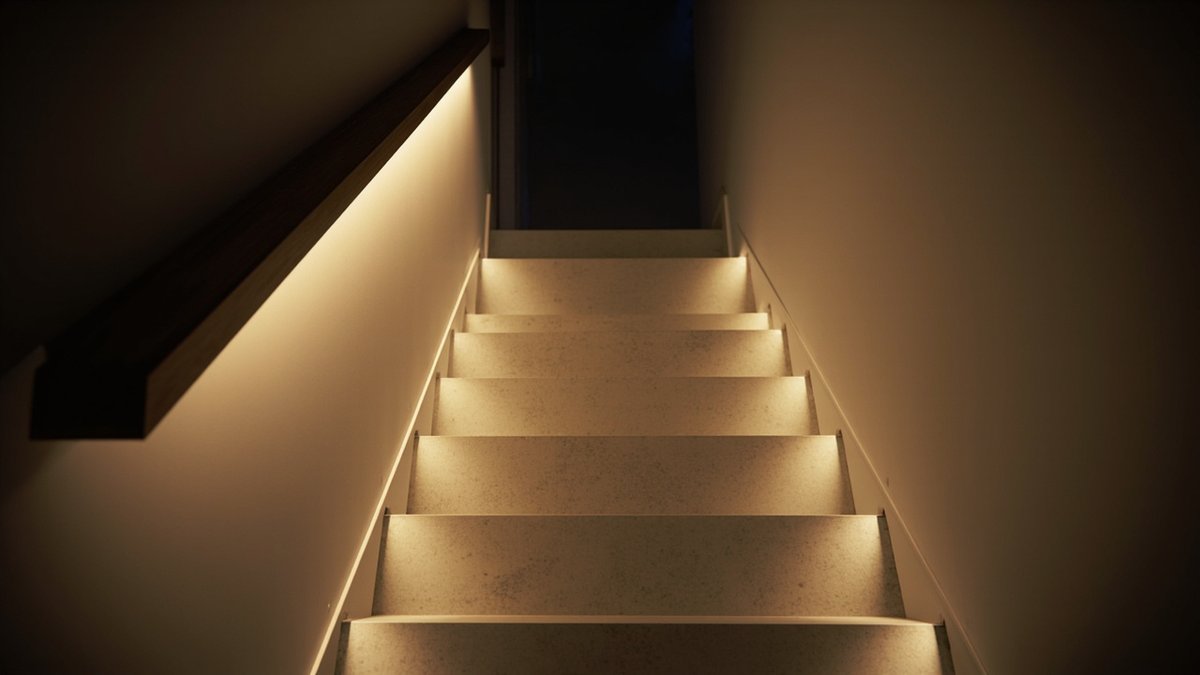 Illustrative concept design: A dark timber handrail on the wall with a warm LED strip beneath it washes light down a straight flight of stone-look treads