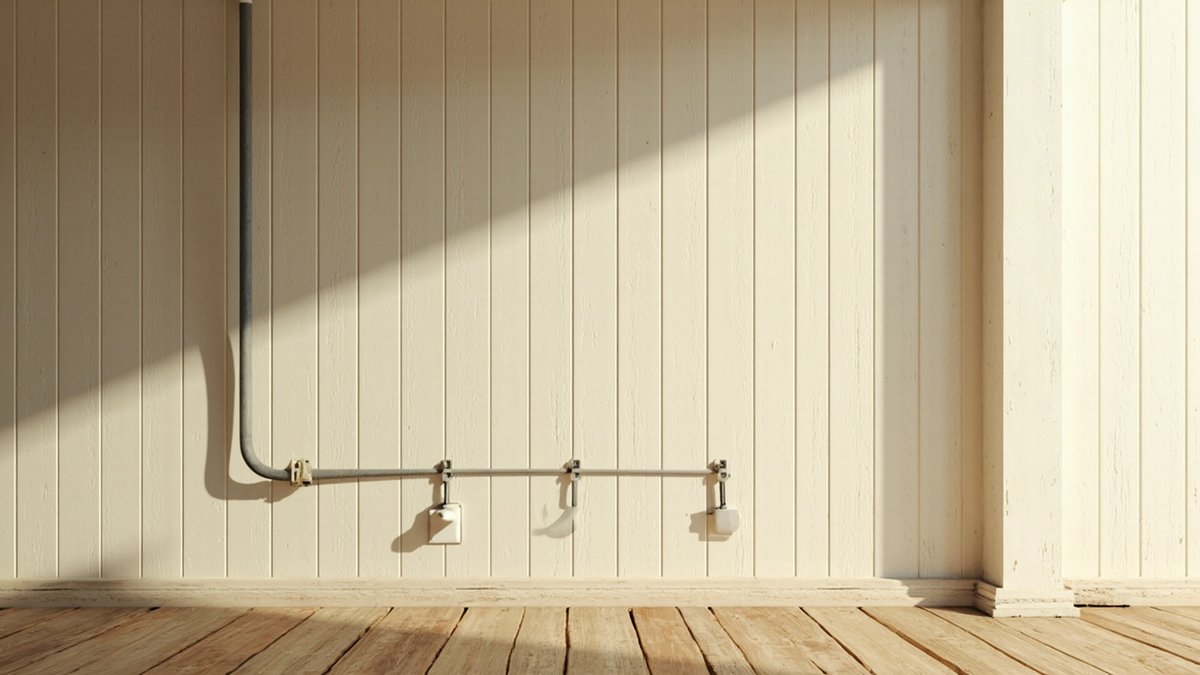 Illustrative concept design: grey metal conduit run on clips along a cream plank wall to white socket boxes