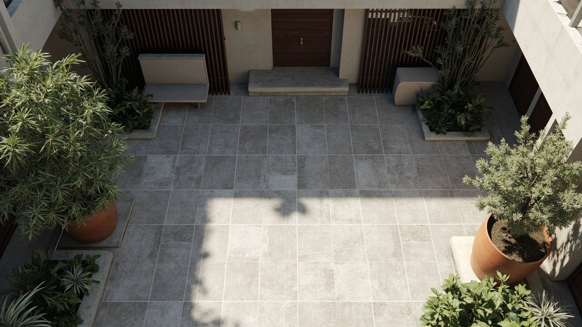 Illustrative concept design: courtyard paved in large grey stone tiles with terracotta pots of small trees, planter beds and a built-in bench