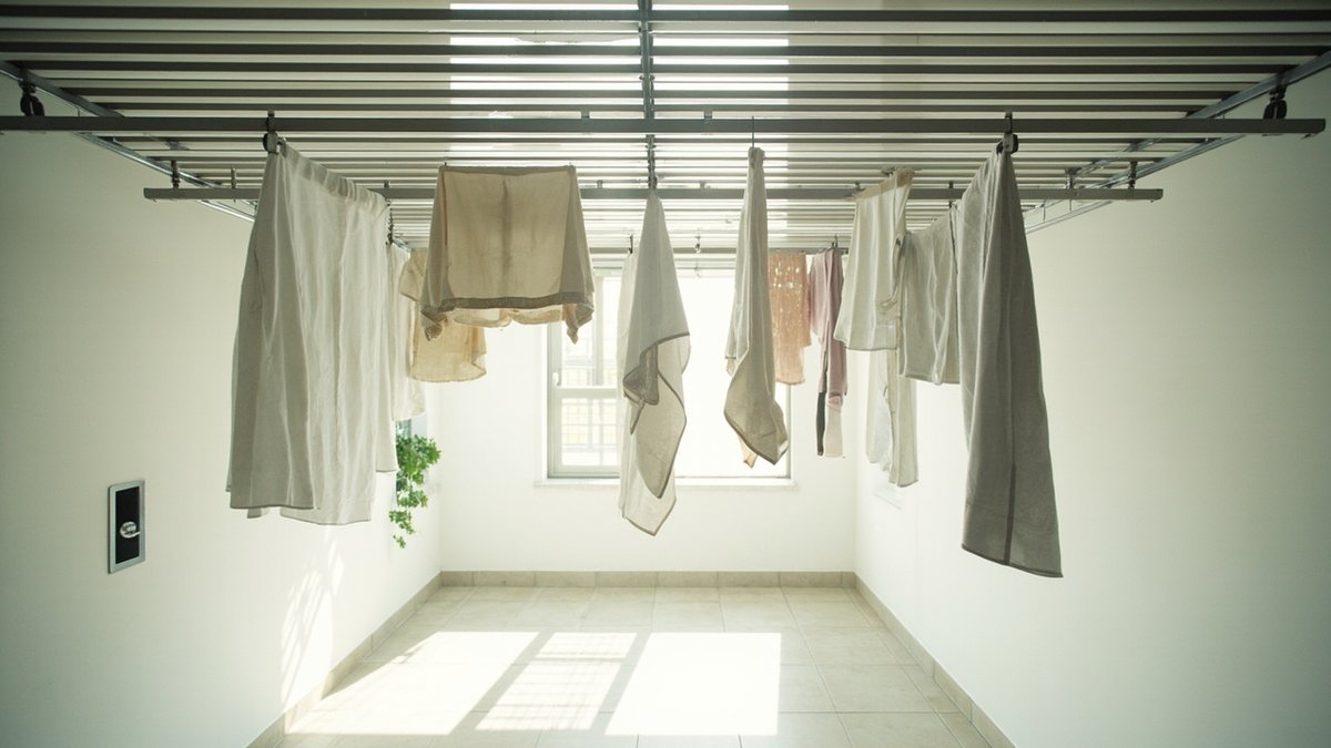 Ceiling track laundry rack system in a service yard