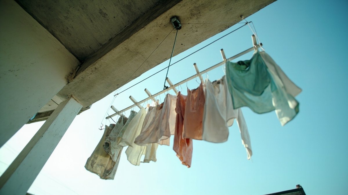 Ceiling-mounted pulley laundry rack with clothes hanging on a yard balcony