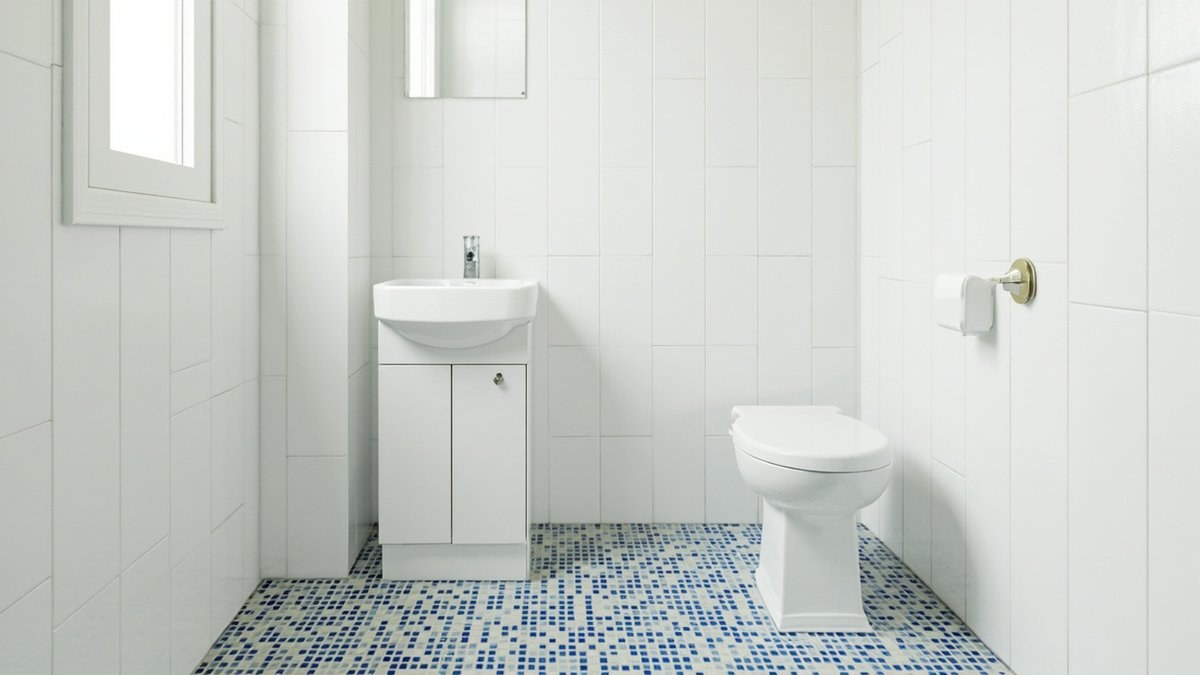 Illustrative concept design: blue and white mosaic floor with white wall tiles, a basin cabinet and a toilet