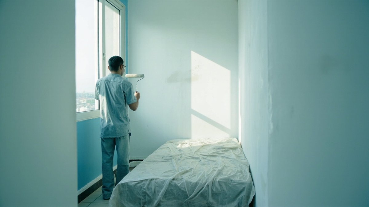 Painter repainting a compact student-rental condo bedroom between tenancies in Bandar Sunway