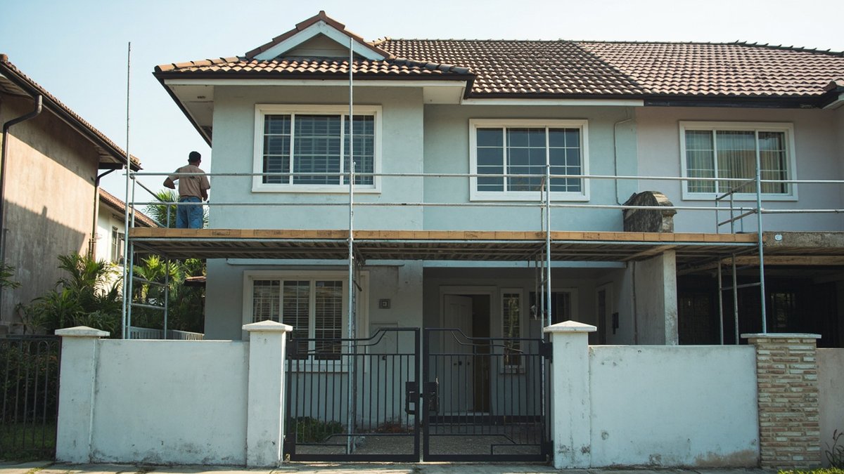 Scaffolding on a 1990s semi-detached house during an exterior repaint in Bandar Utama