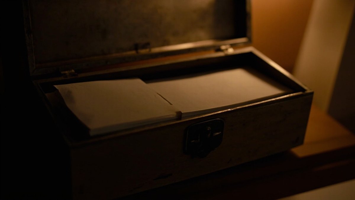 Small lockbox with paper bundles on a shelf representing security deposit rules