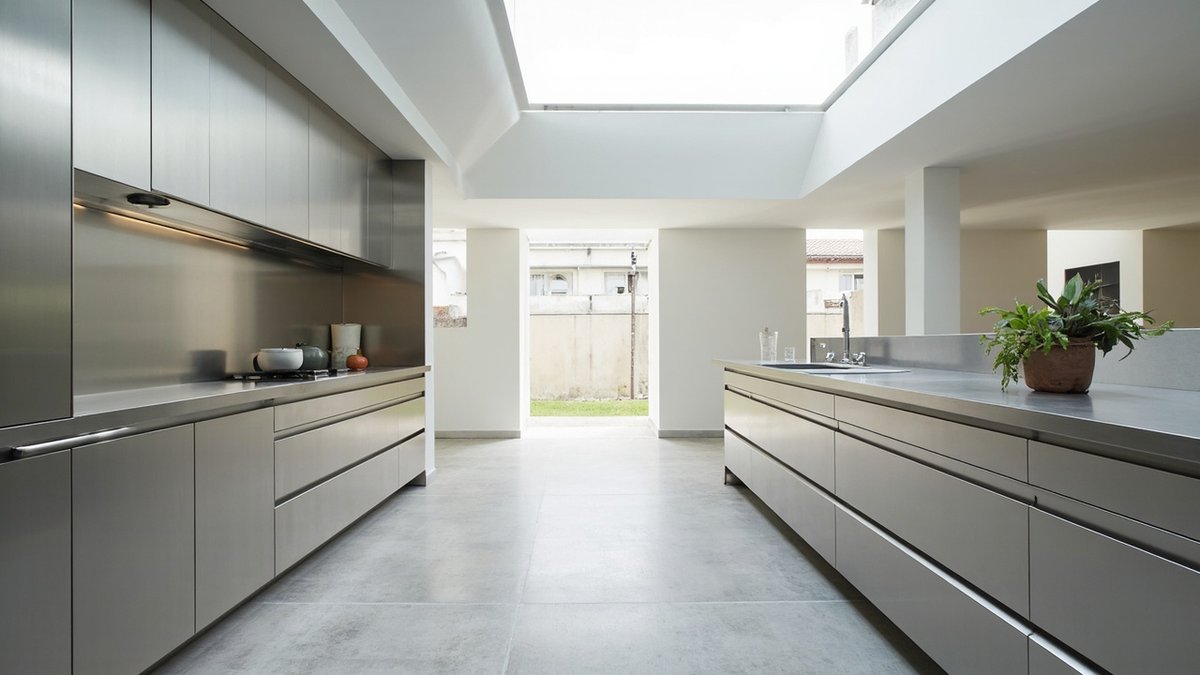 Illustrative concept design: long stainless galley kitchen with a stainless island under a skylight opening