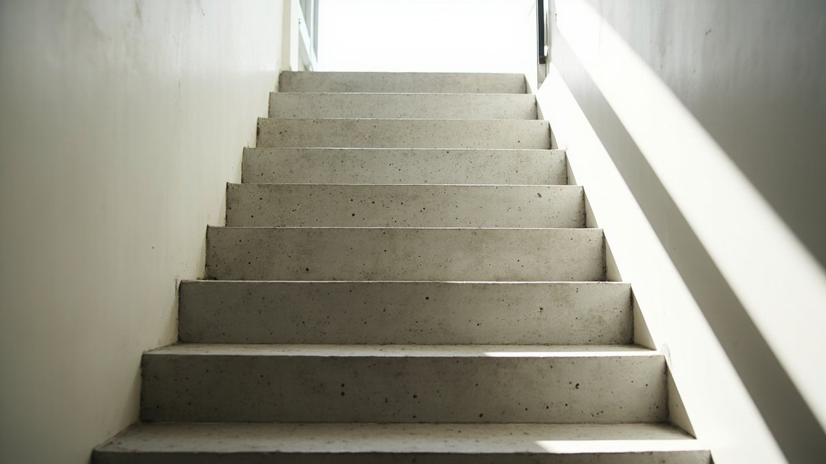 Plain concrete straight staircase with metal balustrade