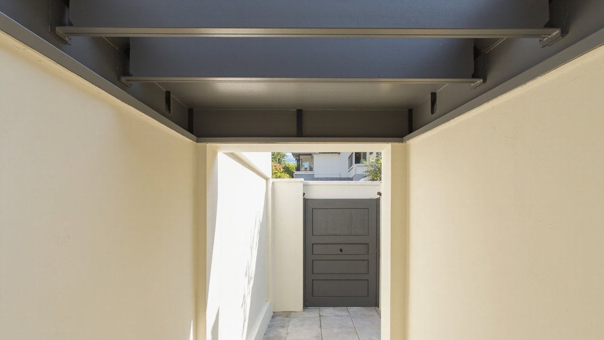 Illustrative concept design: flat grey panel roof on steel beams spanning a narrow terrace back yard between two walls, no posts