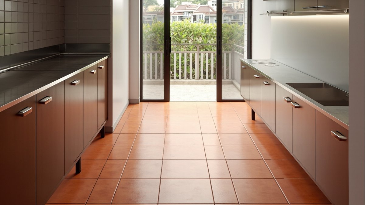 Illustrative concept design: wet kitchen floor of matt square terracotta-look tiles by a stainless steel sink