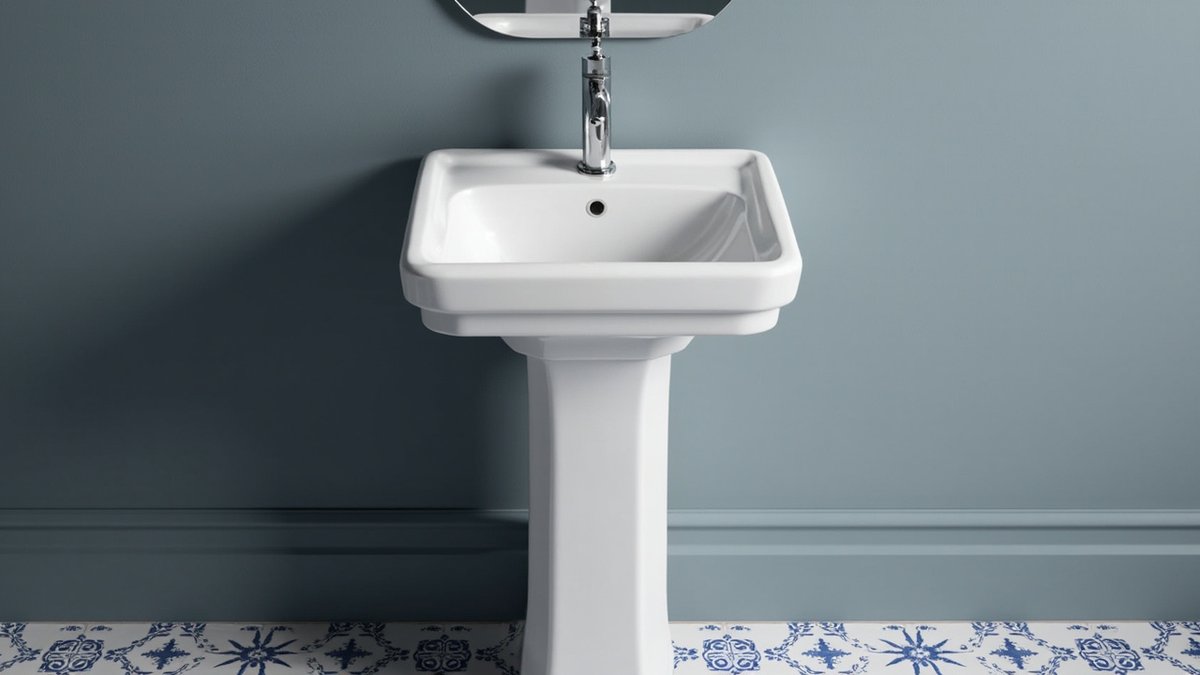 Illustrative concept design: white pedestal basin with a single mixer over a blue and white patterned tile floor