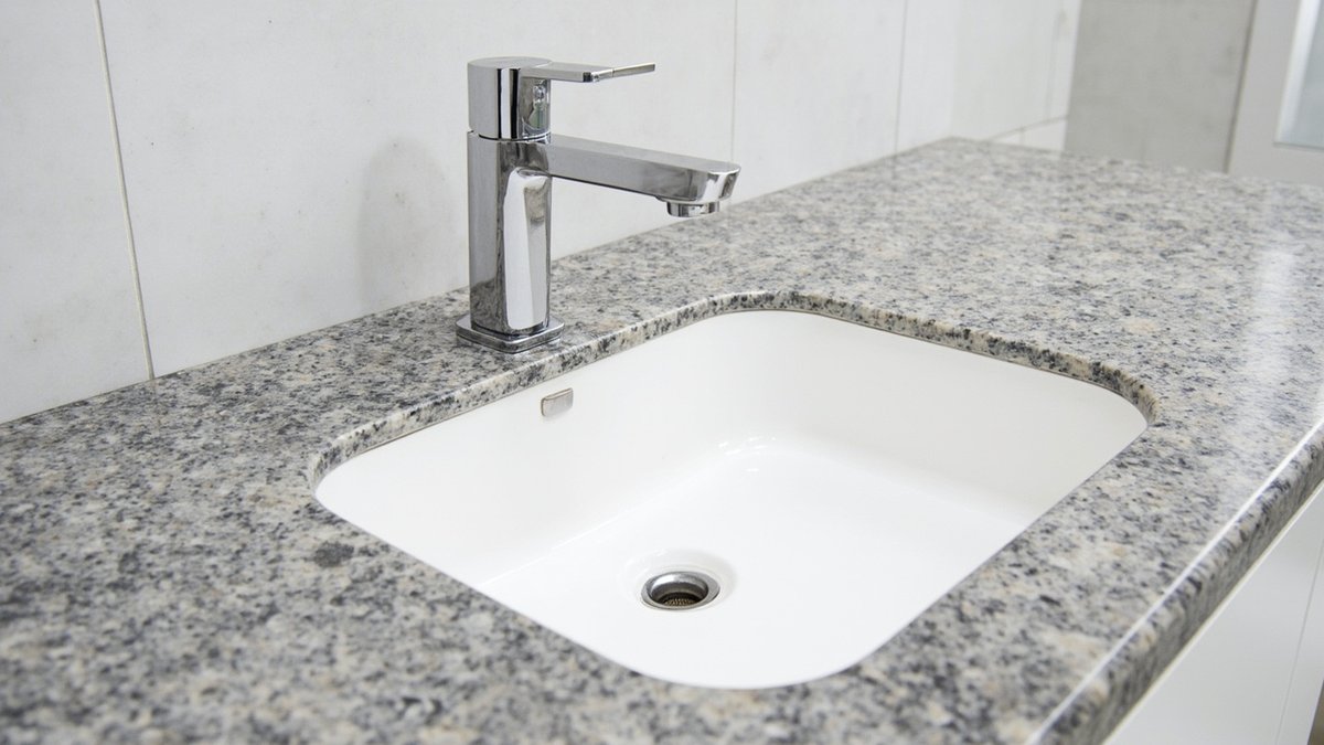 Illustrative concept design: rectangular white undermount basin under a speckled grey granite countertop