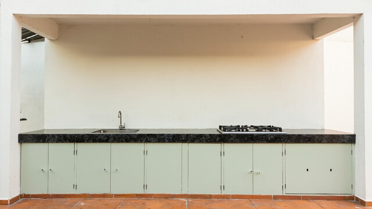 Ilustrasi konsep reka bentuk: kaunter dapur luar tapak konkrit dengan pintu logam hijau sage dan table top granit gelap