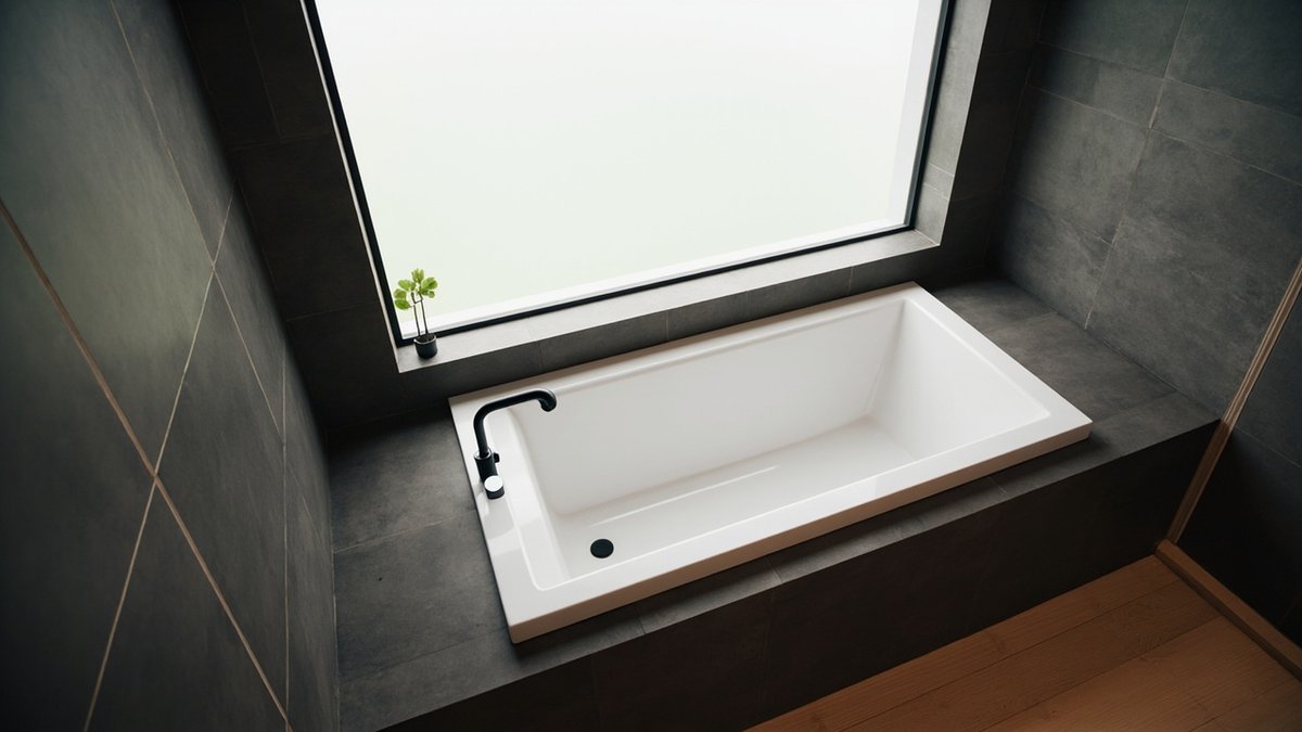 Illustrative concept design: white drop-in bathtub in a charcoal tiled plinth with a wide ledge in a bungalow bathroom