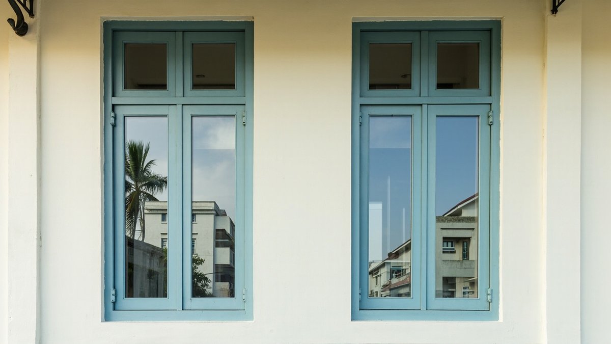 Illustrative concept design: two duck-egg blue painted timber casement windows with fanlights in a cream facade